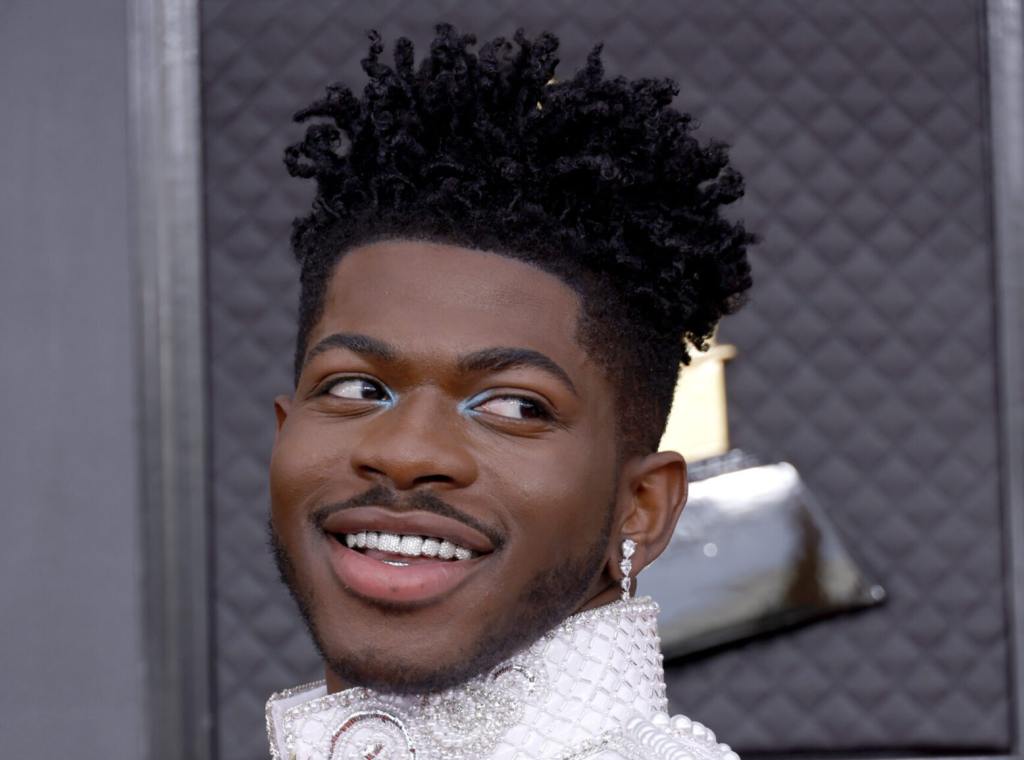 Lil Nas X attends the 64th Annual GRAMMY Awards smiling looking back, Lil Nas X's Most Iconic Fashion Moments Ranked.