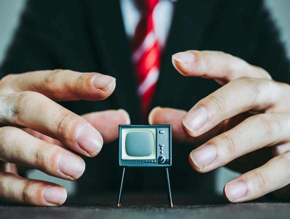 politician with hands around tv