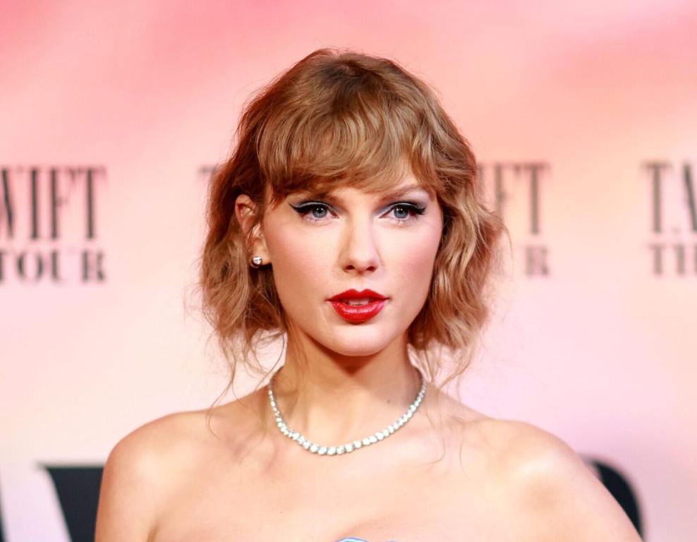 Taylor Swift attends "Taylor Swift: The Eras Tour" Concert Movie World Premiere wearing a strapless dress and pearl necklace.