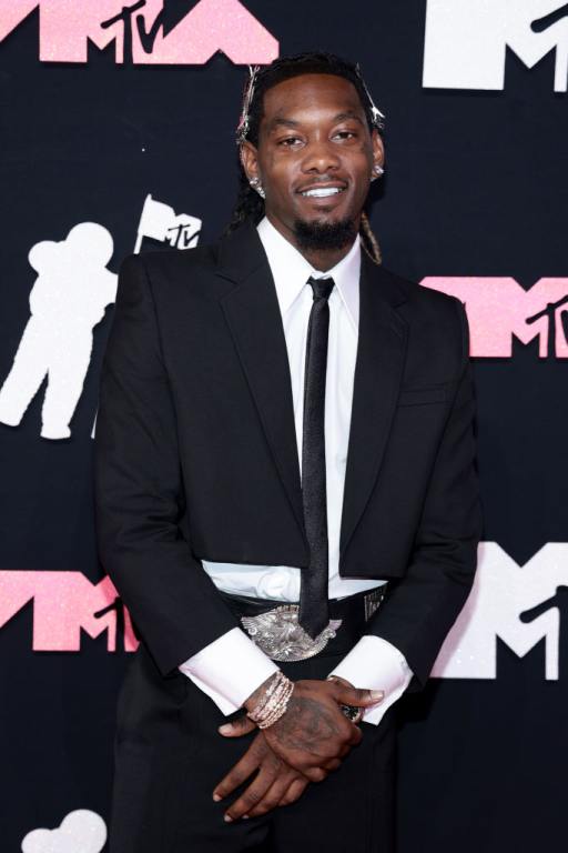 Offset attends the 2023 MTV Video Music Awards smiling with his hands crossed wearing a suit and tie.