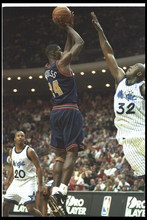 Forward Antonio McDyess of the Denver Nuggets goes up for two as Orlando Magic center Shaquille O''Neal covers him during a game at the Orlando Arena in Orlando, Florida