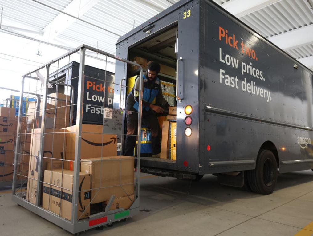 An Amazon driver loads packages into a delivery van at an Amazon delivery station on November 28, 2022 in Alpharetta, Georgia.