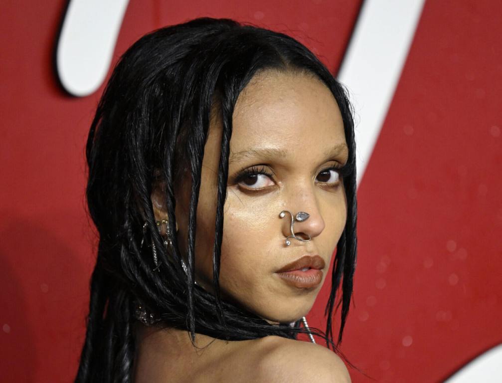 FKA Twigs attends The Fashion Awards 2023 looking back wearing a leaf nose accessory.