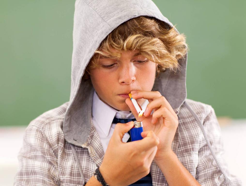 young teen lighting a cigarette