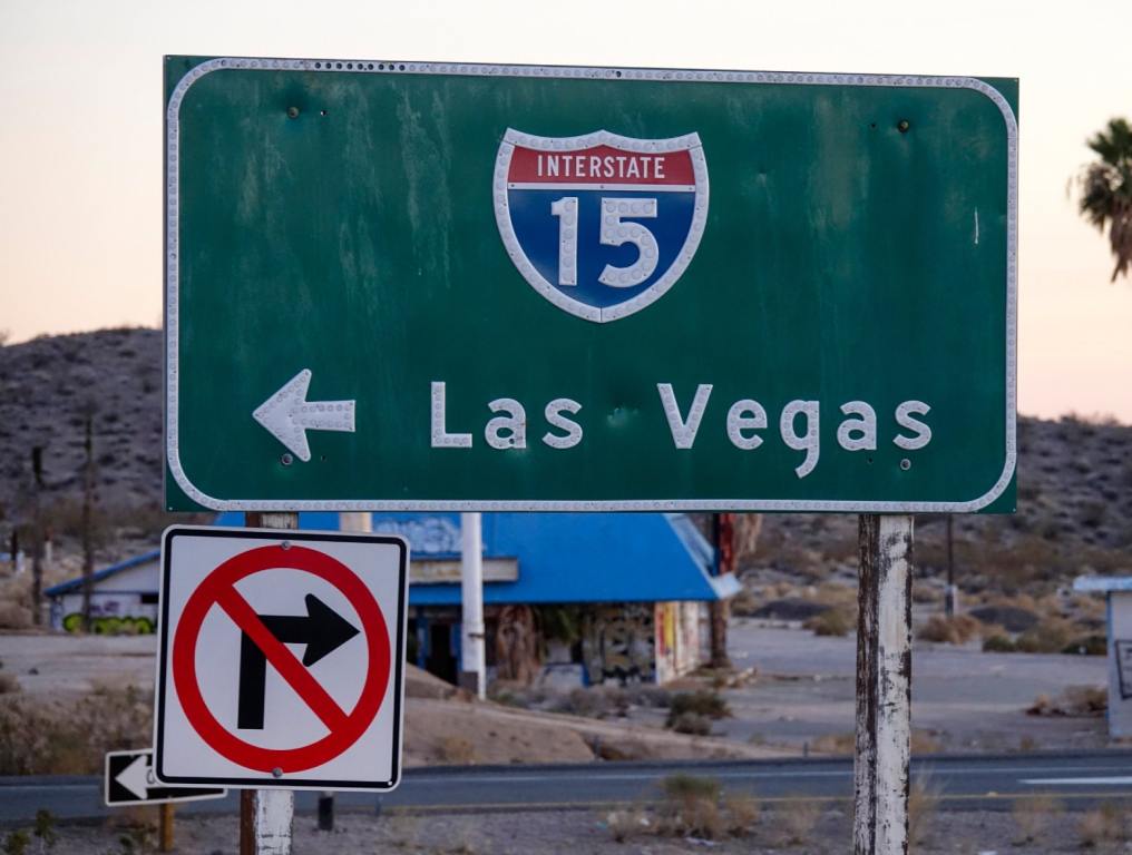 Green I-15 Interstate Sign in Las Vegas. There is a white arrow on the sign, indicating the direction of the onramp.