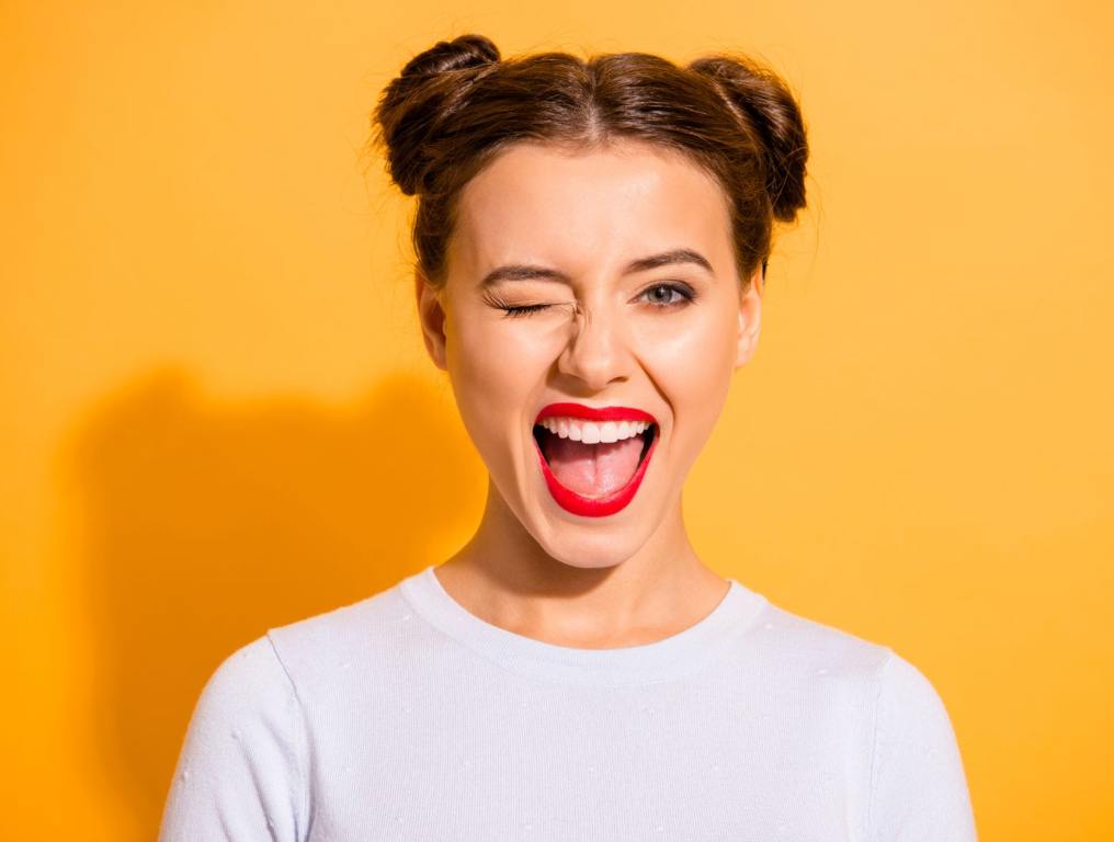 Girl winking with red lipstick on.