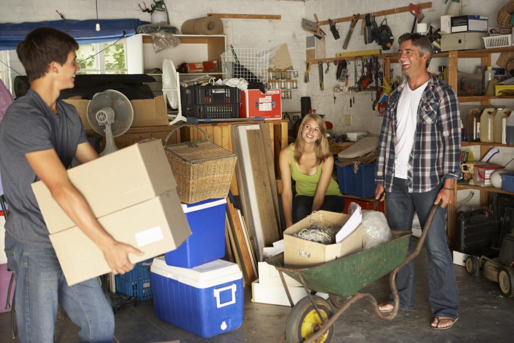 two men and woman cleaning out garage