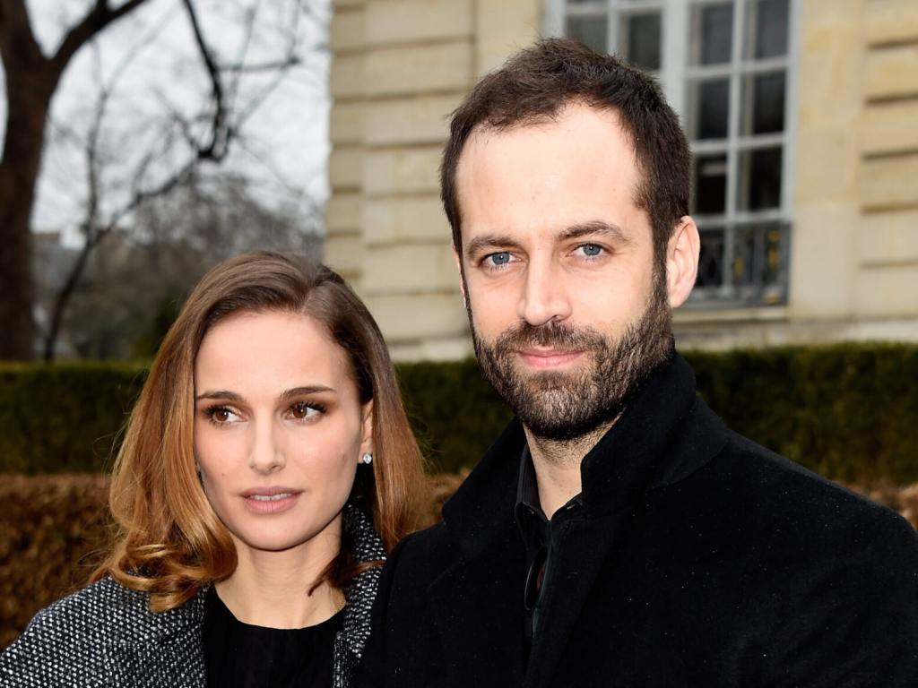 Natalie Portman and Benjamin Millepied attend the Christian Dior show as part of Paris Fashion Week Haute Couture Spring/Summer 2015 both wearing black coats, with natalie looking left with a short brown hair cut.