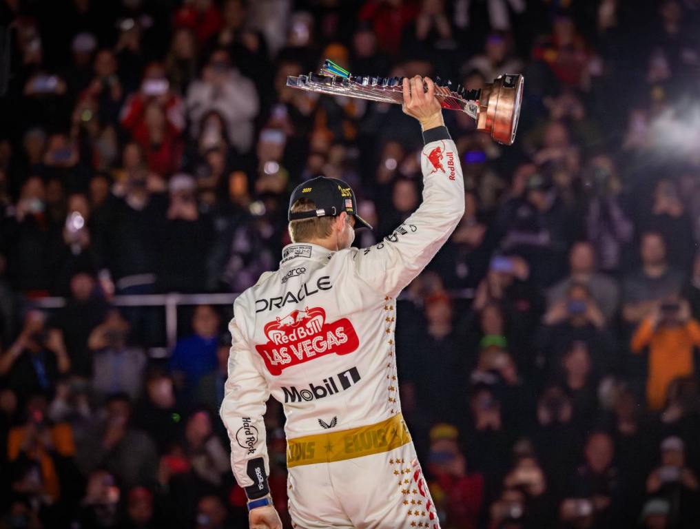 f1 driver max verstappen holds trophy above his head with fans behind him wanting discount f1 tickets