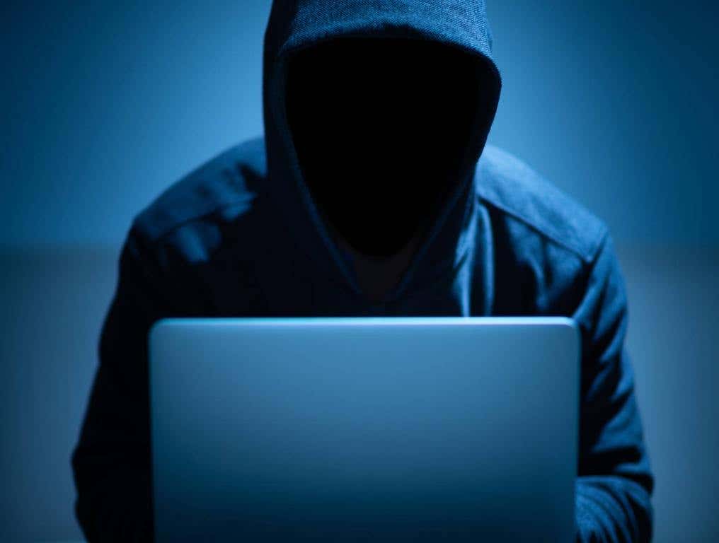 at&t hack hacker dark face using laptop in the dark room