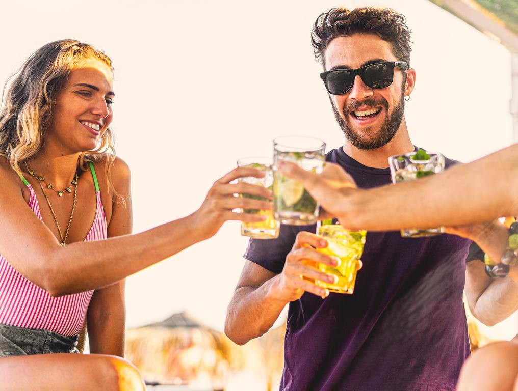 Tequila cheers with a group of friends. A man (right) and a woman (left) are showing in the photo.