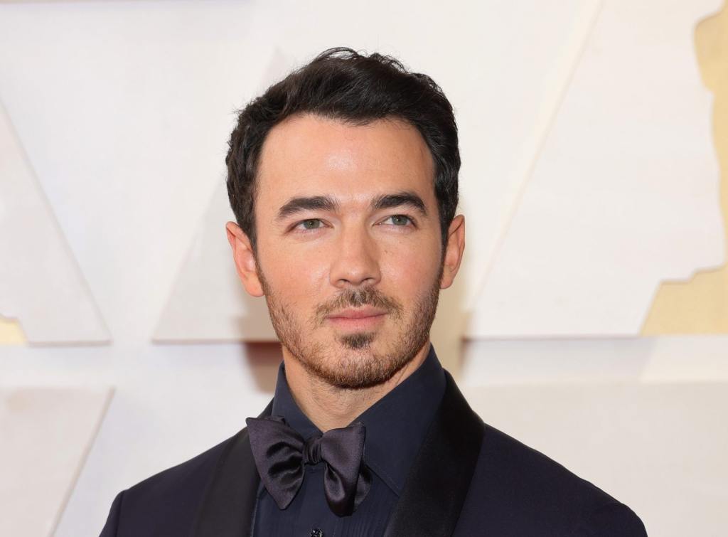 Kevin Jonas attends the 94th Annual Academy Awards looking to the right wearing an all-black tux, Kevin Jonas Reveals His Skin Cancer Diagnosis.