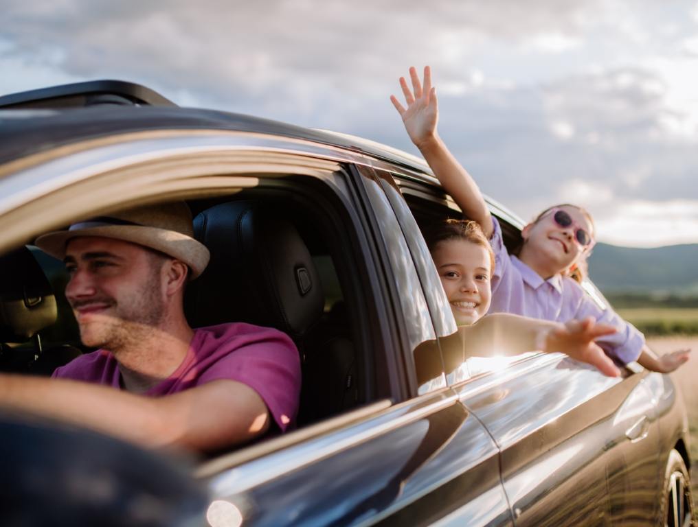 Father and his two kids in the car going on a road trip