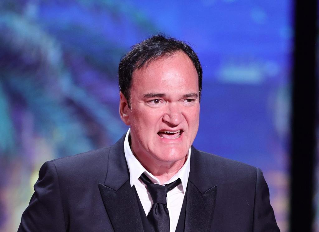 Quentin Tarantino presents The Grand Prix Award during the closing ceremony during the 76th annual Cannes film festival wearing a suit and tie with his mouth open facing right, Quentin Tarantino Said Movie Tickets Are Too High In 2016 - And It's Gotten Worse.