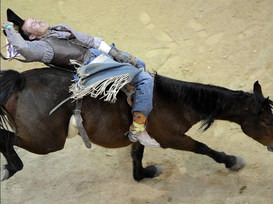 cowboy leaned back on bucking horse. nfr staying in las vegas