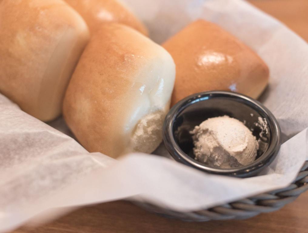 Texas Roadhouse Rolls with Cinnamon Honey Butter in a basket