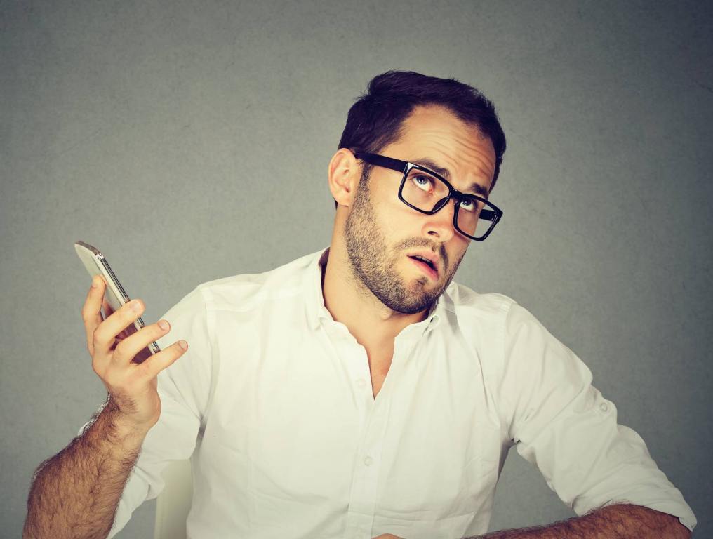 man in white shirt looking annoyed on the phone selling things on facebook marketplace