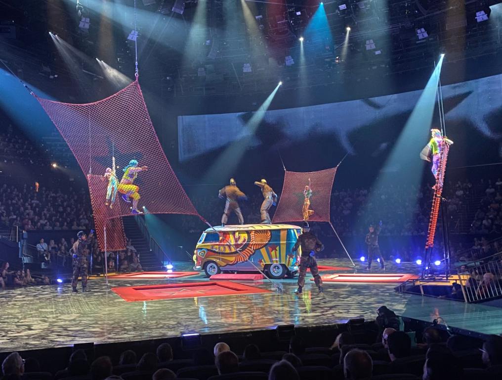 The stage with colorful net trampolines around it with a colorful van in the middle.