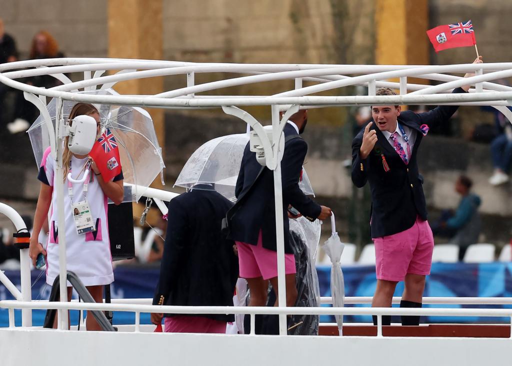 Adriana Penruddocke and Jah-Nhai Perinchief, Flagbearers of Team Bermuda, are seen waving their flag on a boat with team mates along the River Seine during the opening ceremony of the Olympic Games Paris 2024 on July 26, 2024 in Paris, France.