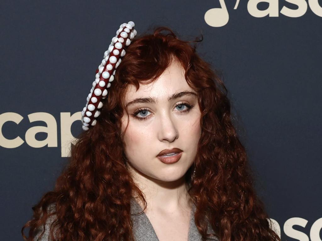 Chappell Roan attends the 2024 ASCAP Pop Music Awards at The Houdini Estate with long red curly hair wearing a side barette and grey blazer, 6 of Chappell Roan's Wildest Outfits.