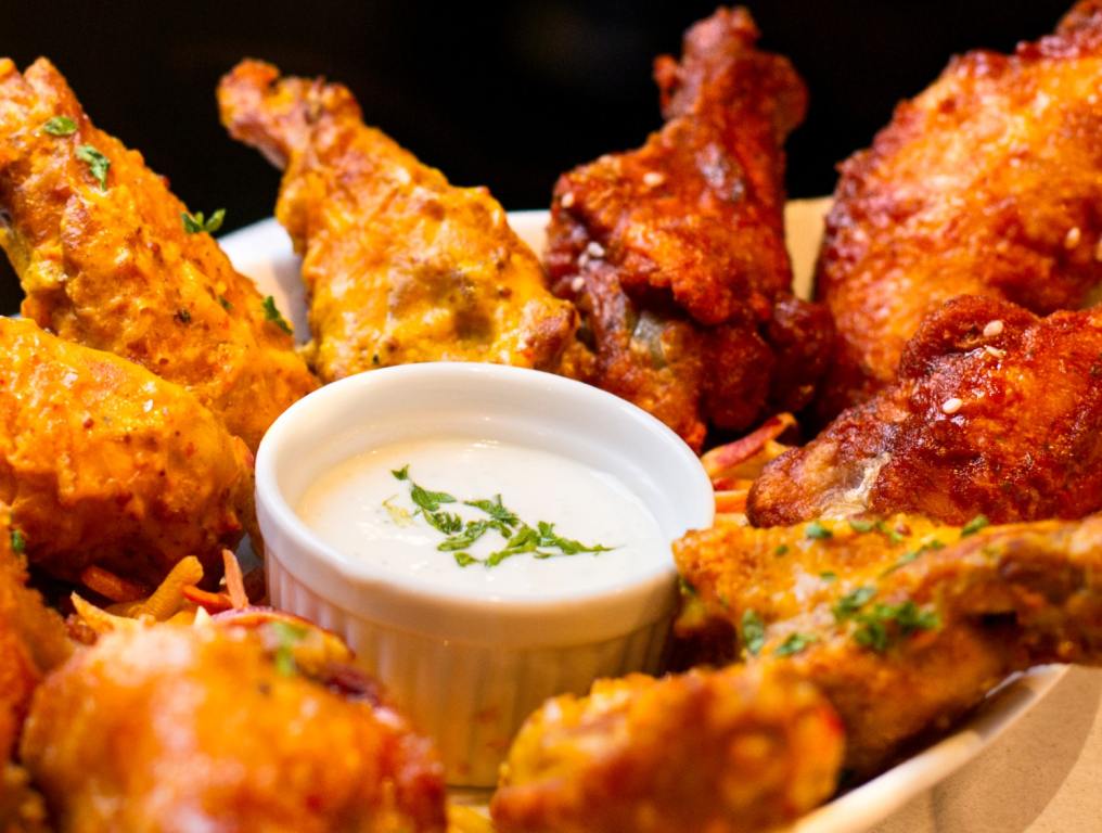 A variety of flavors of jumbo chicken Wings and ranch. National Chicken Wing Day Deals.