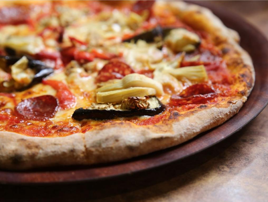 A pizza on a dish. This story is about Blaze Pizza being fined by the U.S. Department of Labor.