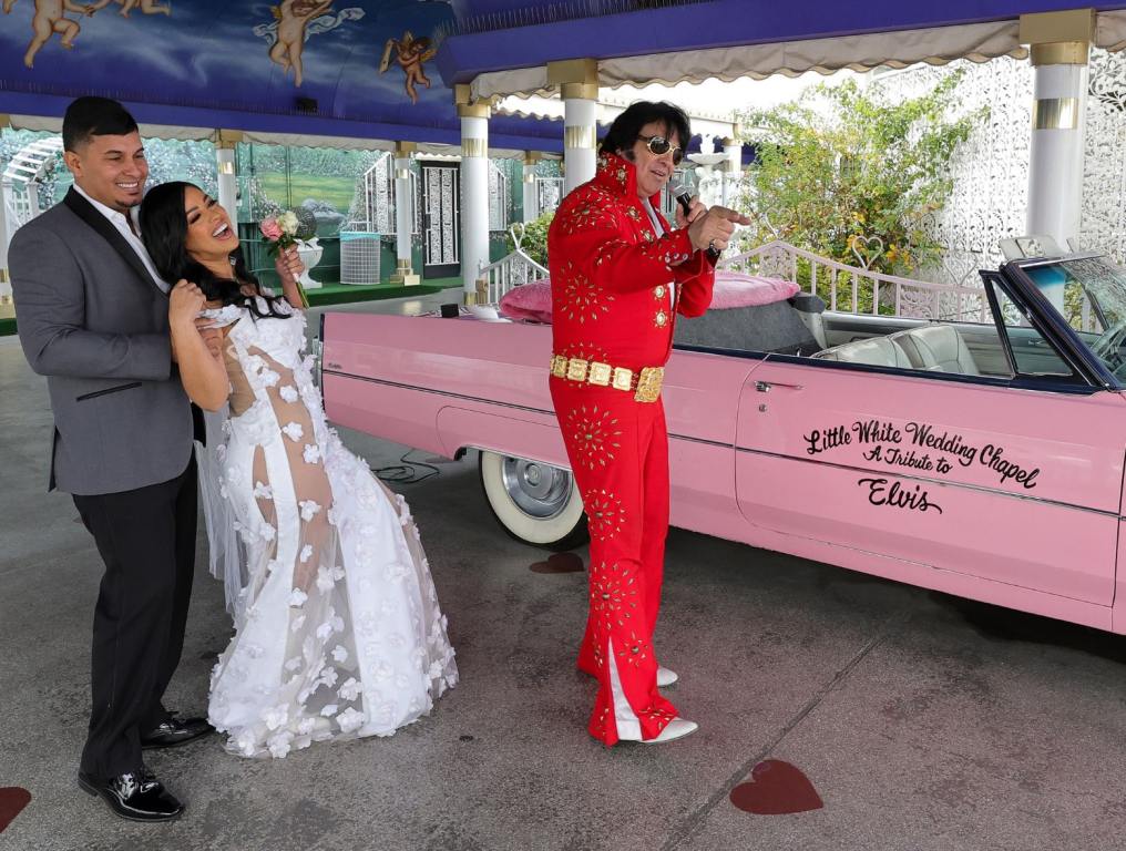 Emil Guzman and Marie Fernandez of Puerto Rico dance as Elvis Presley impersonator Michael Conti sings while officiating their wedding ceremony in front of a pink Cadillac at the Little White Wedding Chapel on December 31, 2023 in Las Vegas, Nevada. People from across the world flock to wedding venues in Las Vegas to say "I do."