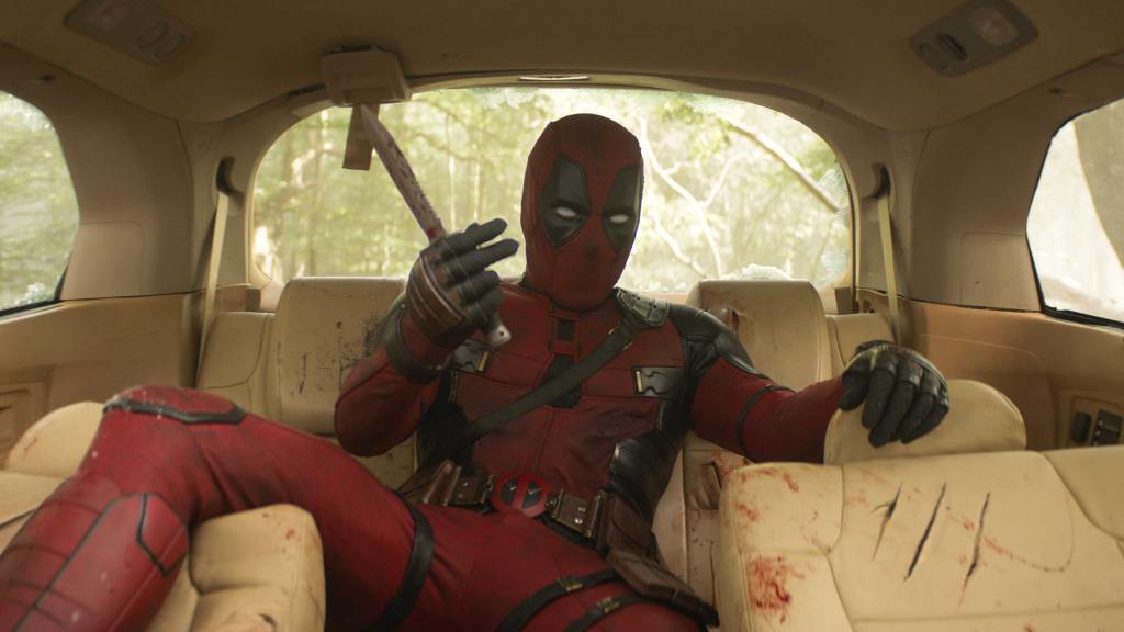 Deadpool sitting in the backseat of a car