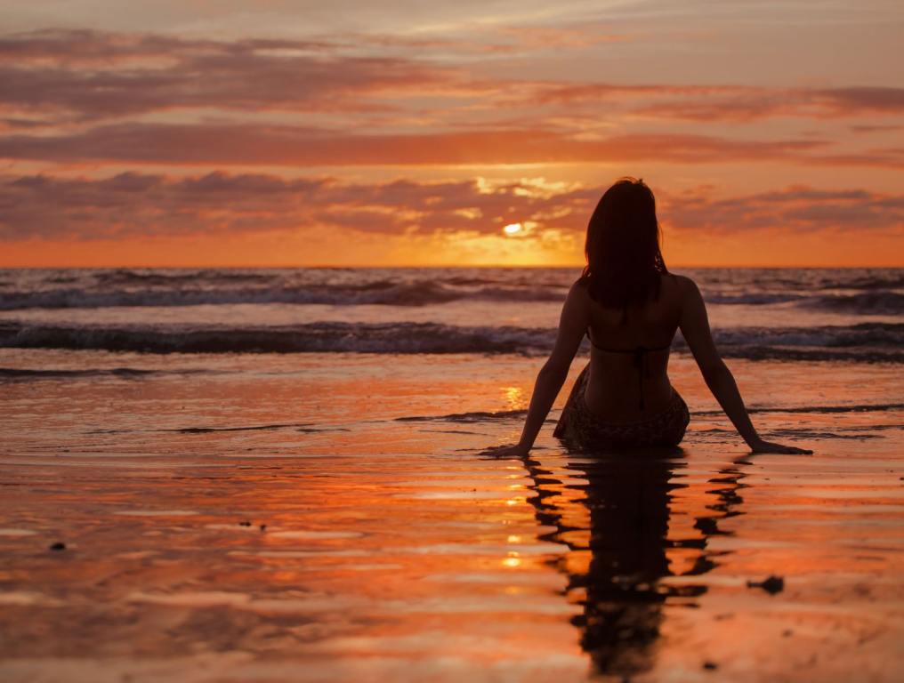 Woman watching sunset. Before you ring in the new season, you should go through a late-summer checklist and do some special things before summer is over.