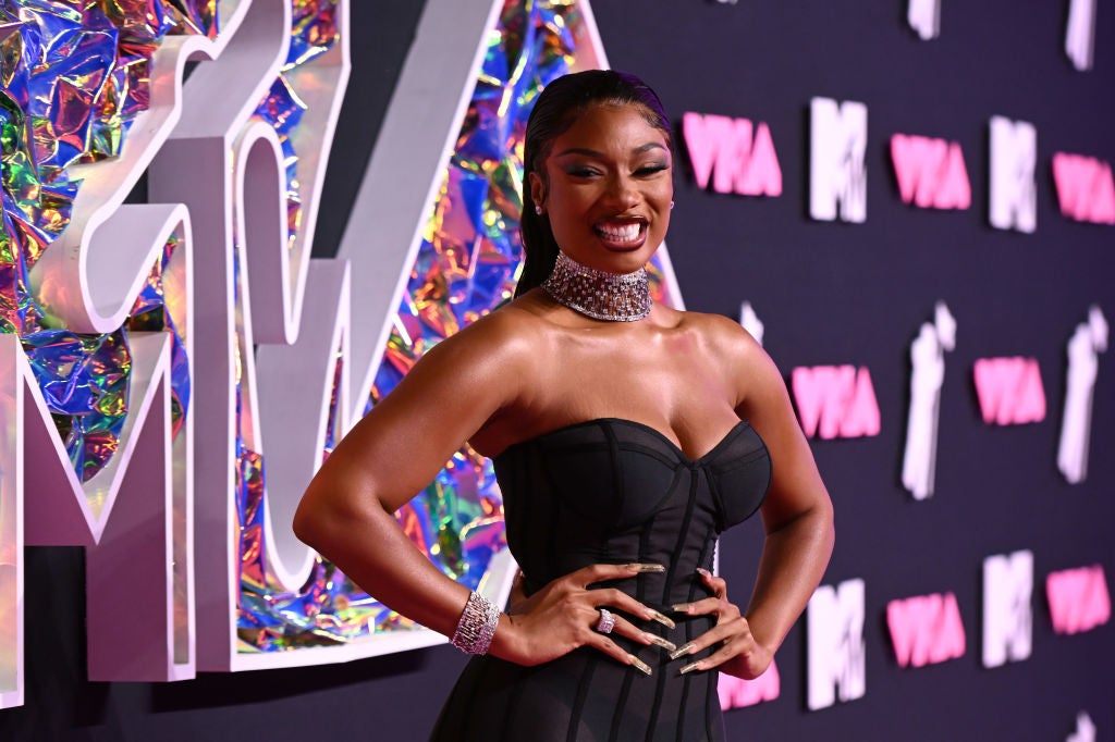 Megan Thee Stallion smiling in a black corset dress at the 2023 Video Music Awards.