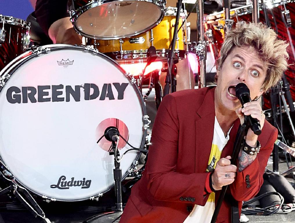 billie joe armstrong singing into microphone in front of drum set