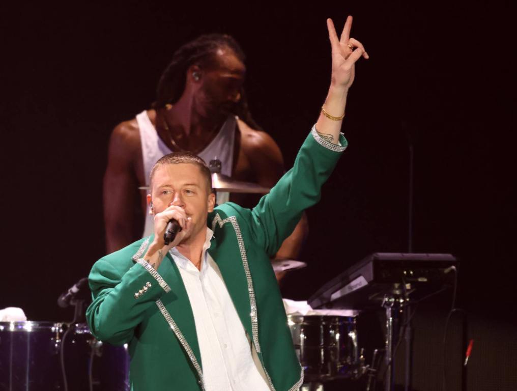 macklemore with hand up giving peace sign