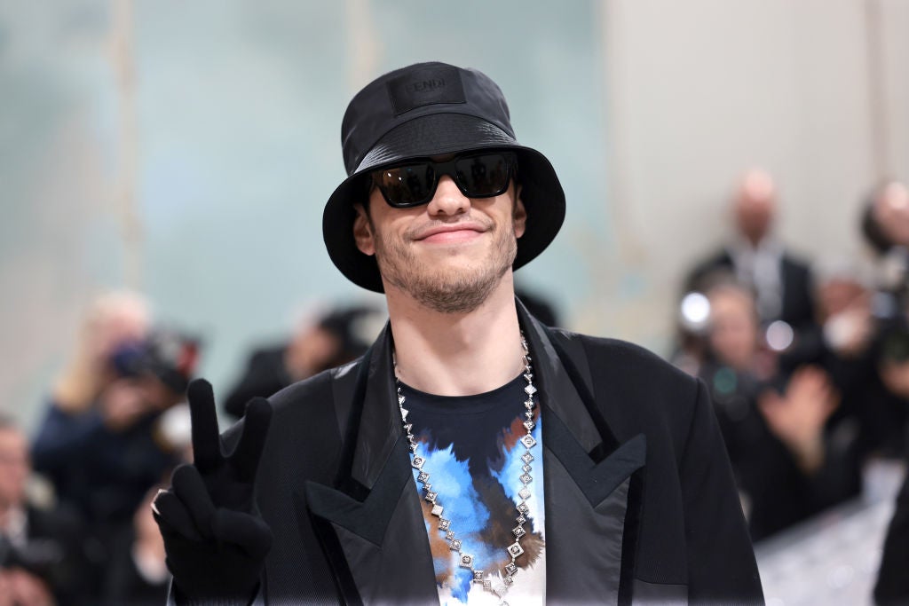 Pete Davidson in a black hat and black jacket with shades