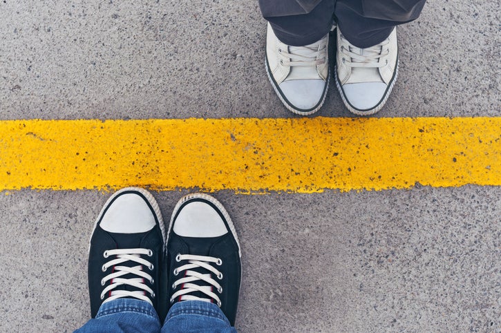 Sneakers from above. Male and female feet in sneakers from above, standing at dividing line.