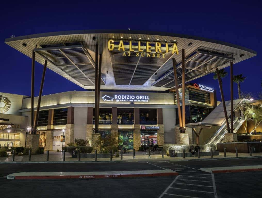 An exterior facade of the Galleria Mall at Sunset in Henderson, Nevada shows signage and a restaurant in front.