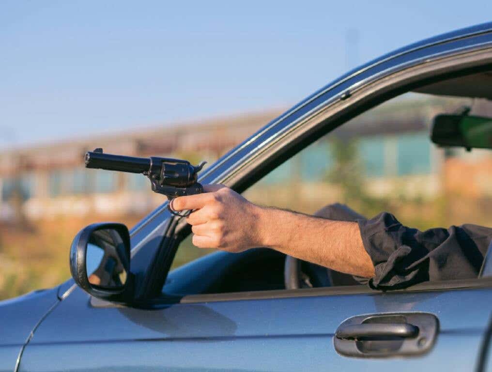 man sticks gun out at california drivers illustration